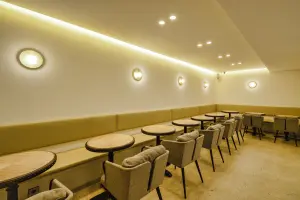 따뜻한 조명과 붙박이 좌석의 아늑한 카페 공간